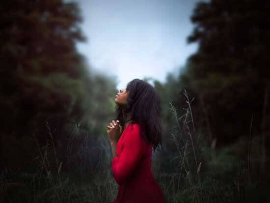 Woman in red praying to Jesus, as He is with her through the presence of another Person of the Godhead, the Holy Spirit