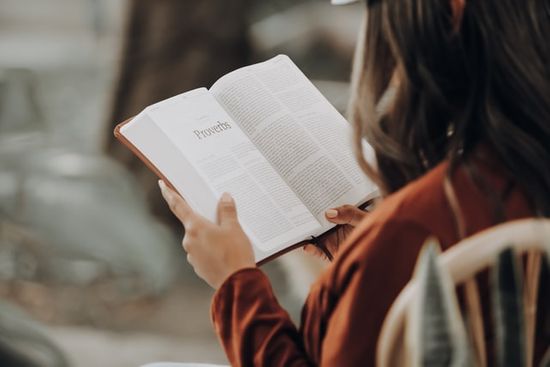 Woman reading Proverbs as we learn how Sabbath School lesson study guides focus either on a Book of the Bible or on a Topic.