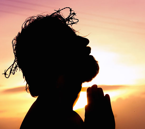 Silhouette of Jesus Christ praying to His Father in Gethsemane as He bore our grief and carried our sorrows (Isaiah 53-4).