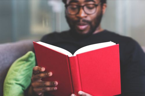 Man reading a red book as we learn how the Adventist Church recognizes the priceless gift of the writings of Ellen White.