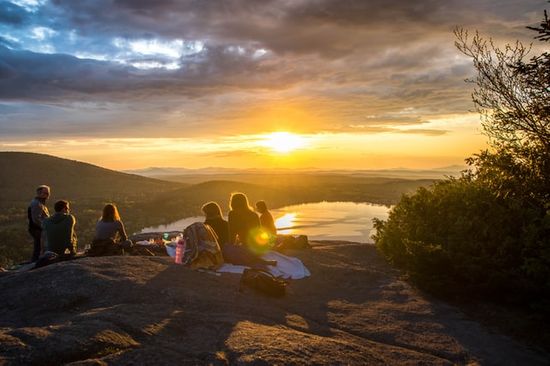 Families sitting on a hill and watching the sunset on the seventh day Sabbath