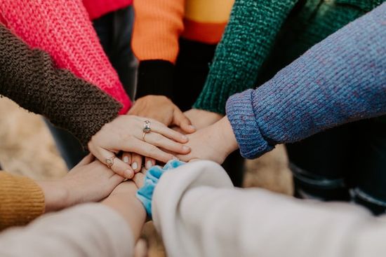 Hands piled together in harmony, just like the Bible writers harmonized through the Holy Spirit