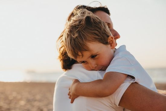 A child being held by his parent, representing a secure relationship