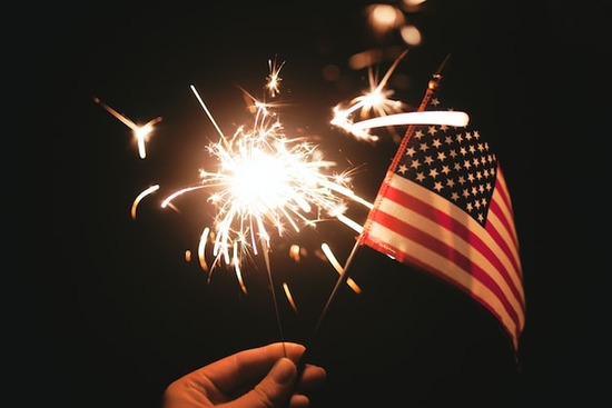 An American flag with fireworks in the background to represent the patriotic holidays Adventists celebrate