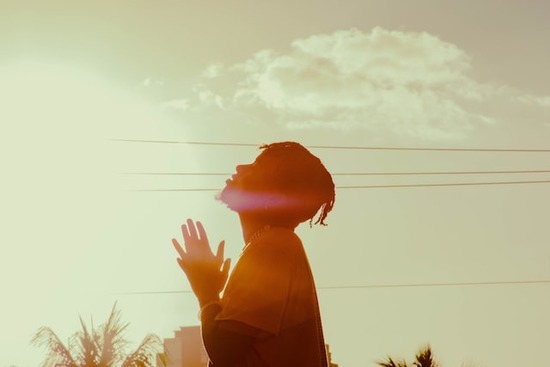 A man looking to heaven and praying that he would make music and movie choices that glorify God