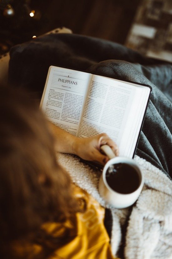  A woman studying her Bible with a mug of tea beside her