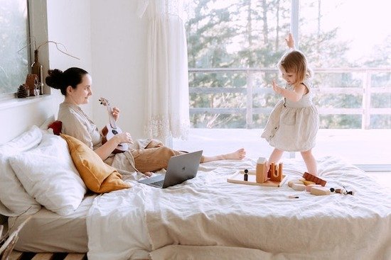 A mother playing the ukulele for her daughter