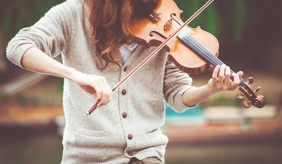 A woman playing a violin to make music that honors God