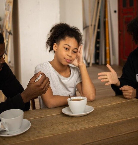 A girl sitting between her parents who are arguing