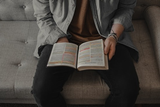 A man sitting on a couch and studying what the Bible says about predestination